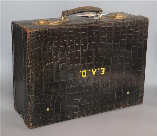 A George V crocodile skin toilet case with five silver mounted jars